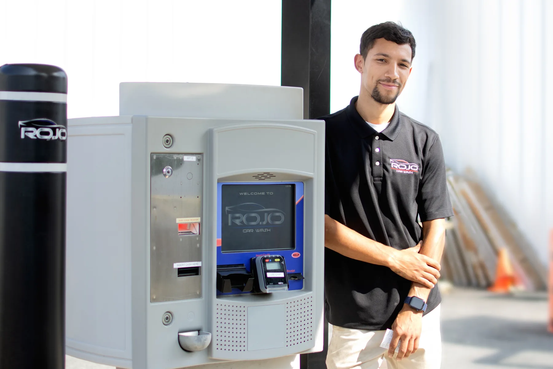 RoJo Car Wash employee standing beside the automated payment kiosk