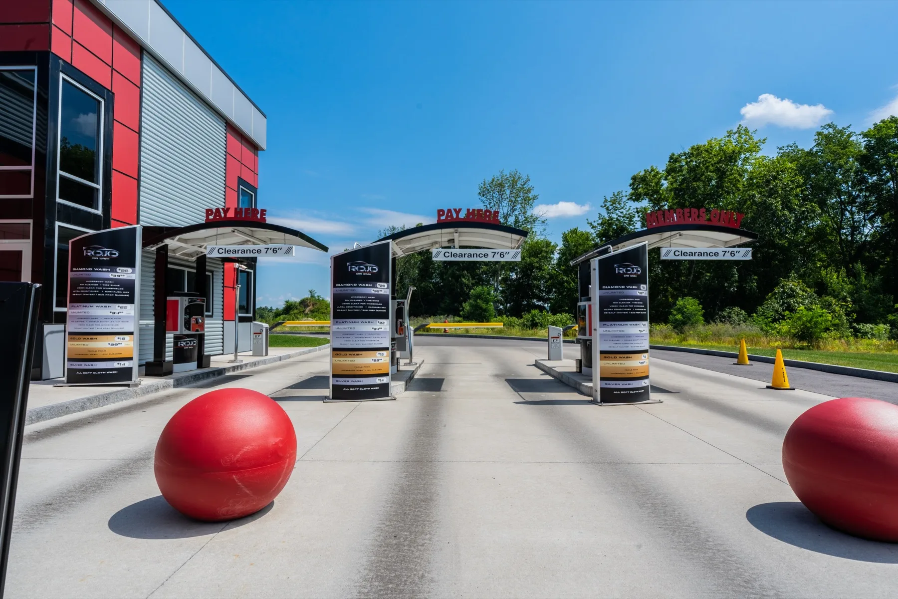 RoJo Car Wash pay station lanes with menu kiosks and red brand spheres